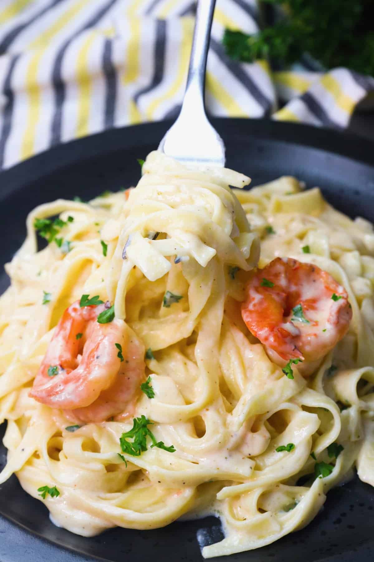 Twirling delectable fettuccine on a fork with amazing shrimp Alfredo