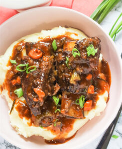 Tender, saucy Instant Pot Short Ribs served over creamy mashed potatoes