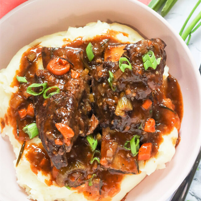 Tender, saucy Instant Pot Short Ribs served over creamy mashed potatoes