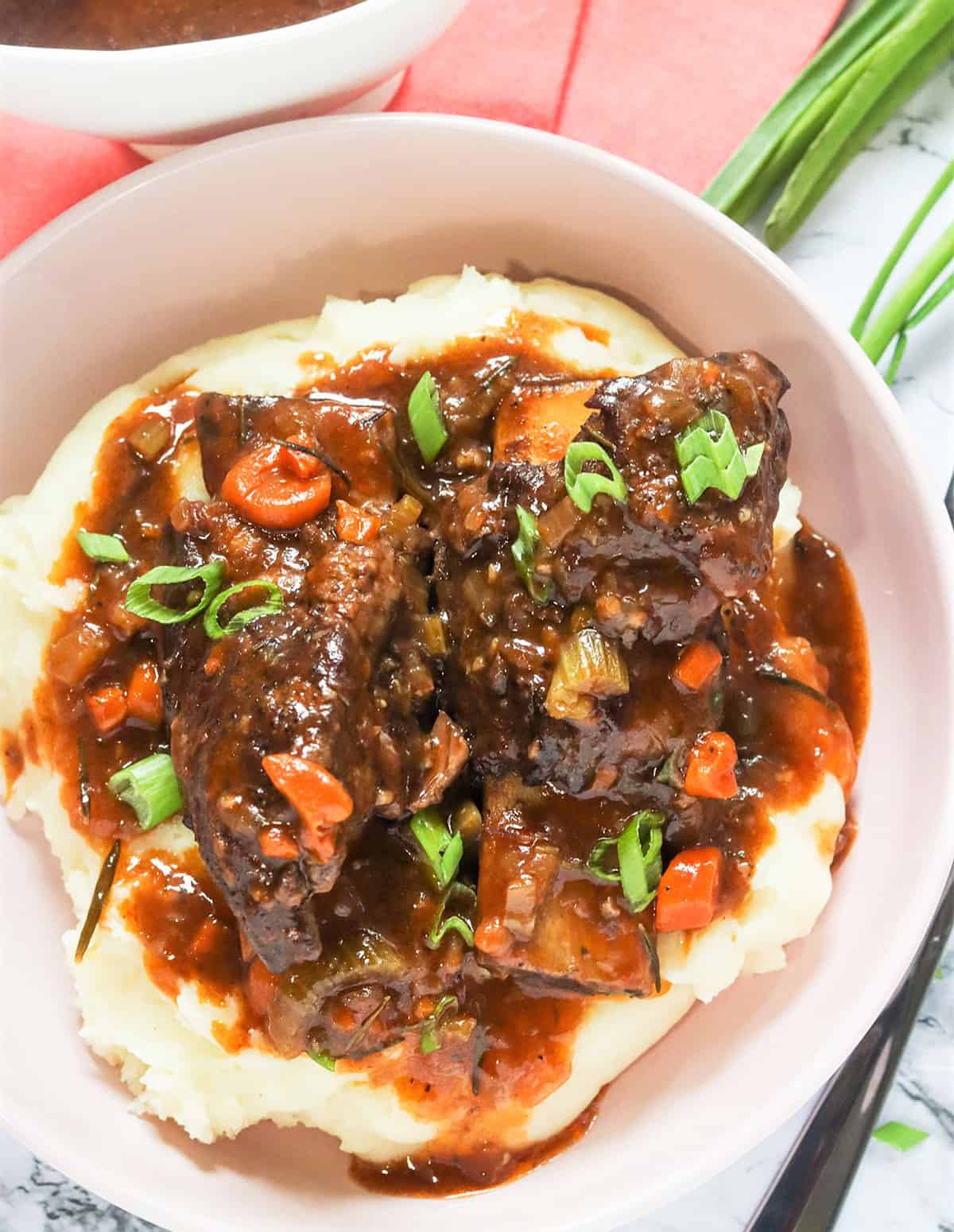 Tender, saucy Instant Pot Short Ribs served over creamy mashed potatoes 