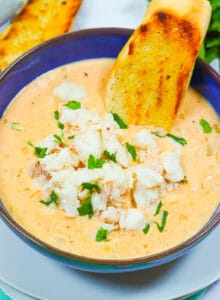 Dipping crusty bread into a steaming hot bowl of she crab soup