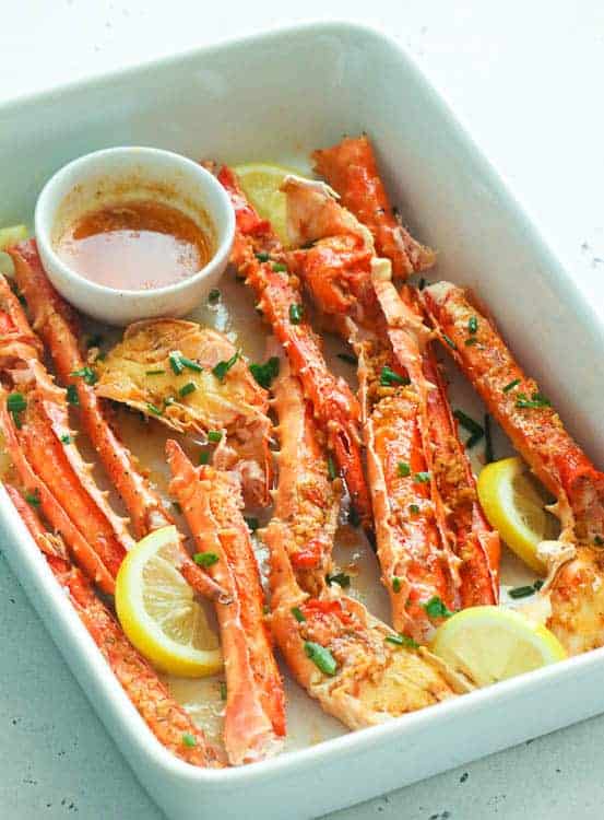 Baked Crab Legs in Butter Sauce dish brushed with garlic, butter, lemon, and Creole seasoning sauce