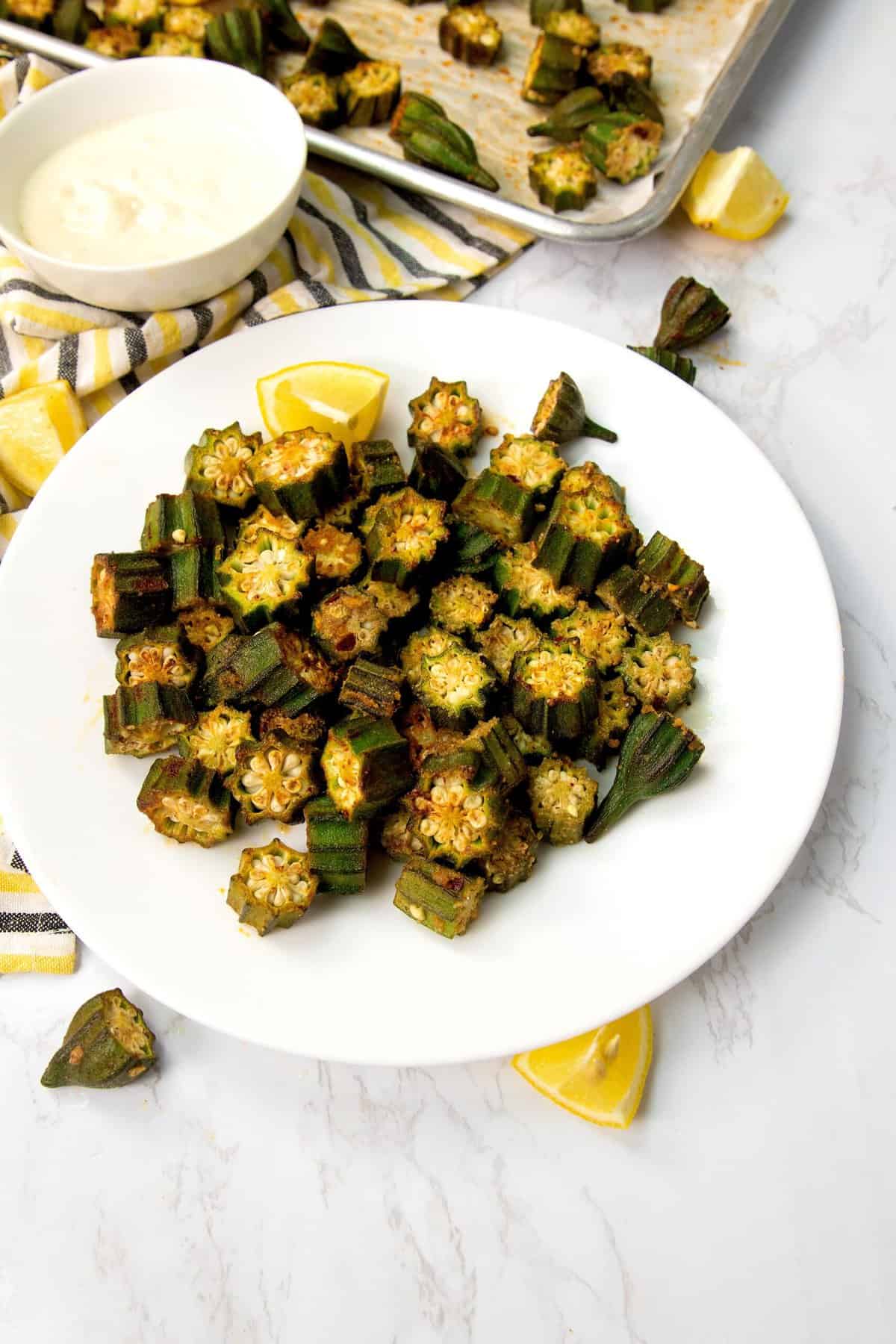 Enjoying a plateful of oven roasted okra with sauce in the background