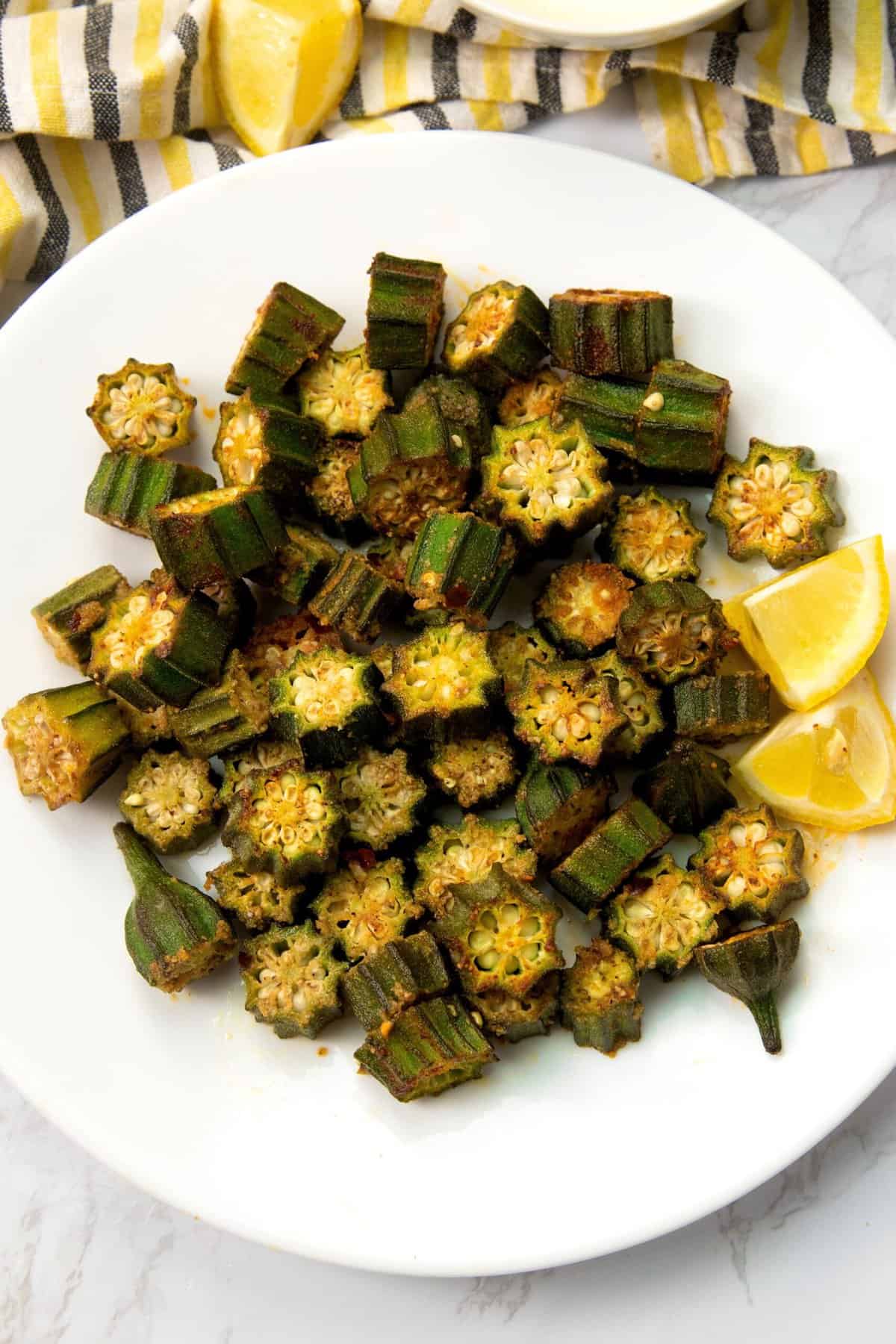 Oven roasted okra with a lemon wedge ready to serve
