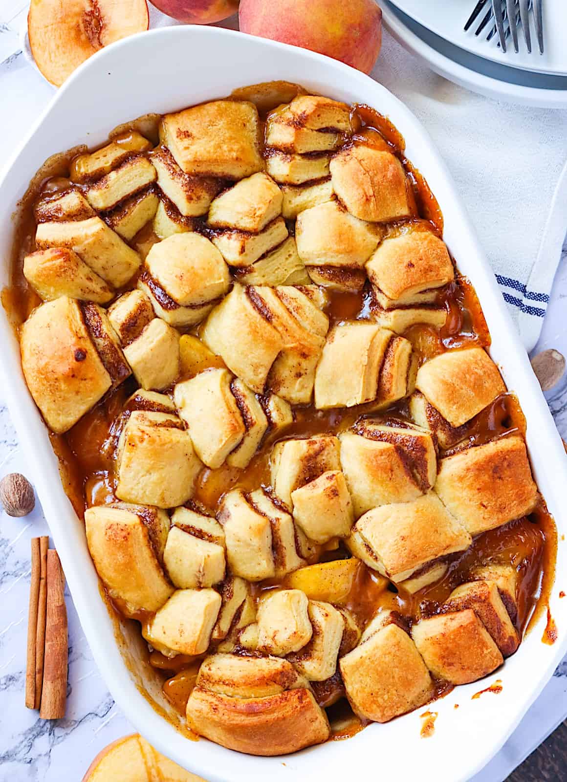 Steaming hot Cinnamon Roll Peach Cobbler ready to enjoy