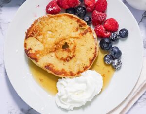 Enjoying a satisfying French Toast Bagels with whipped cream and berries