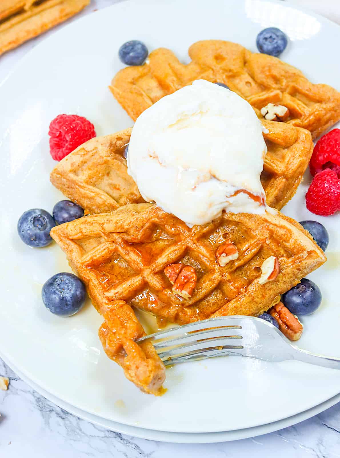 Diving into insanely delicious sweet potato waffles with vanilla ice cream and berries