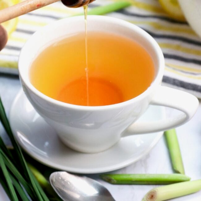 Drizzling honey in a deliciously hot cup of homemade lemongrass tea