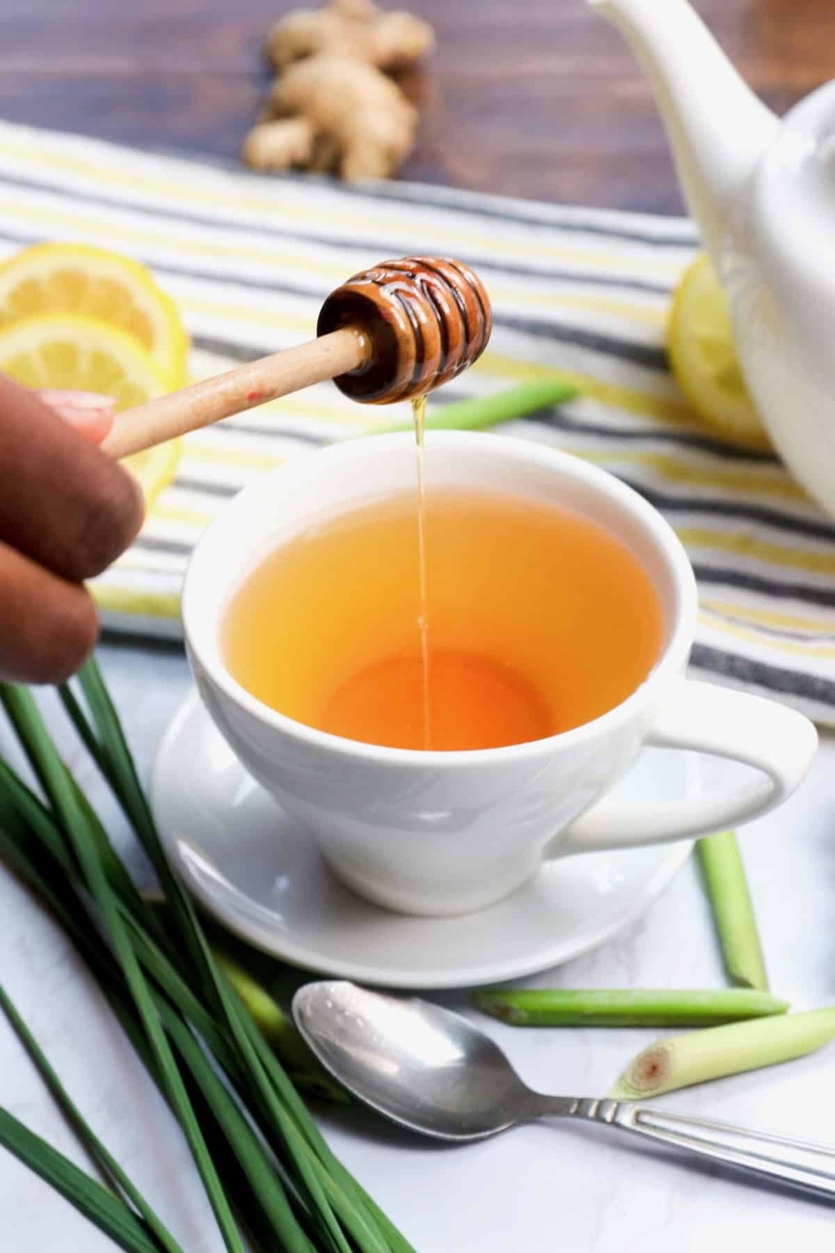 Drizzling honey in a deliciously hot cup of homemade lemongrass tea