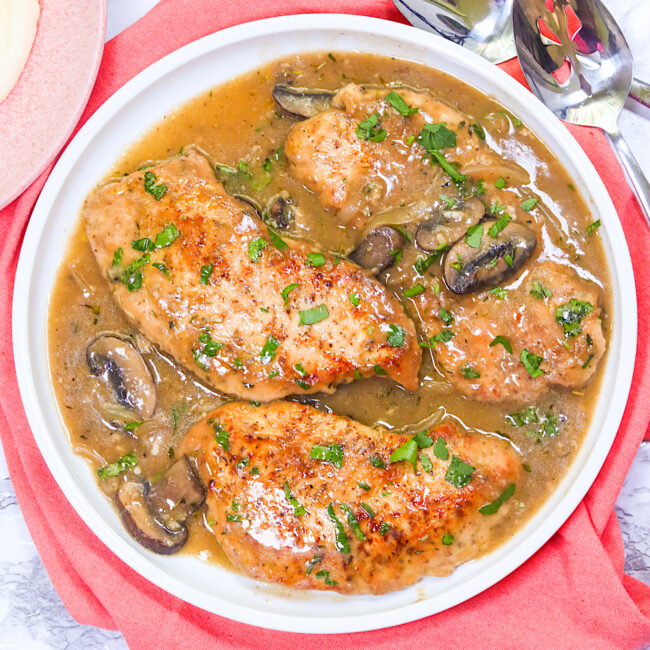 A serving plate full of crazy tender smothered turkey chops