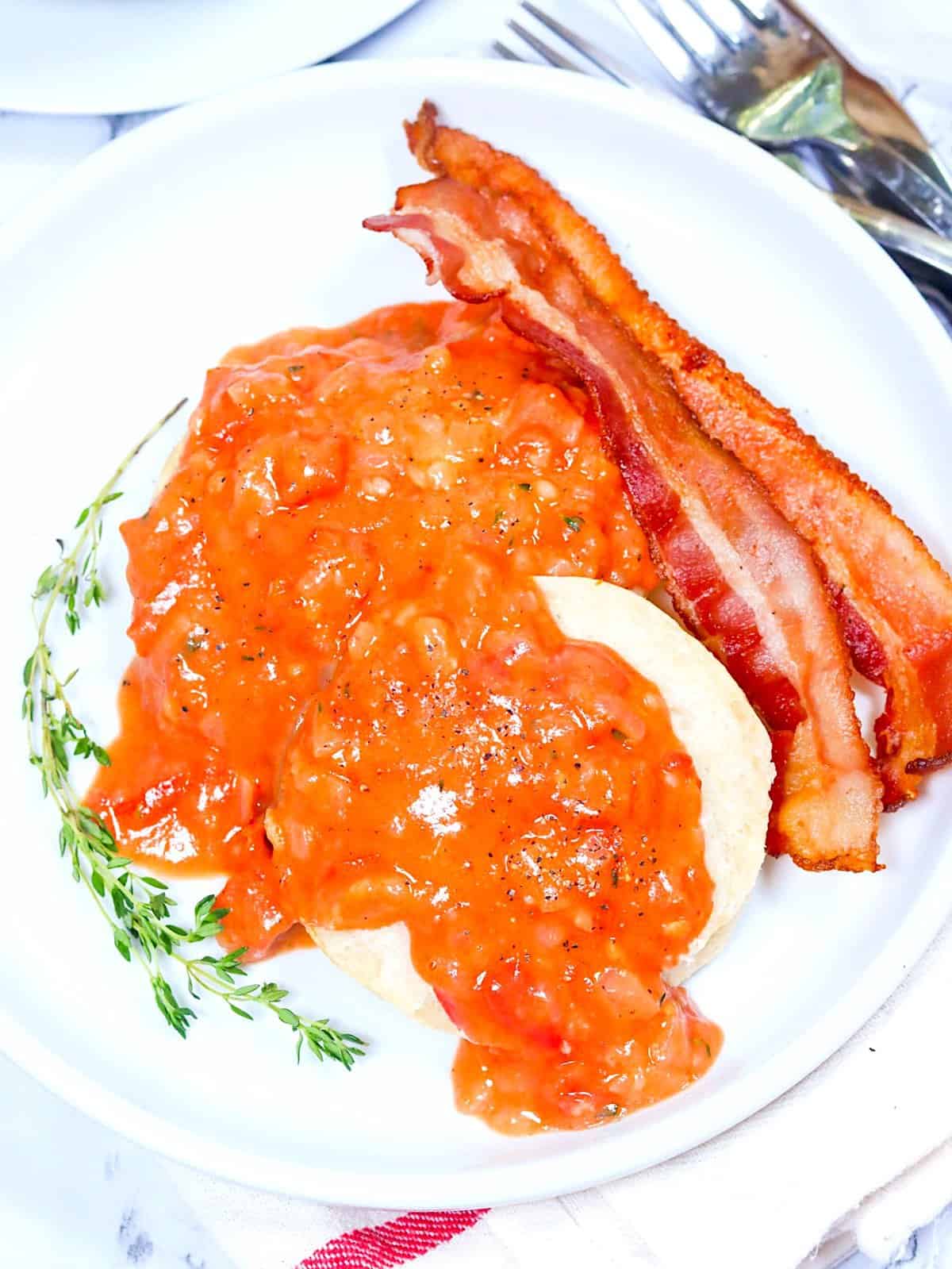 Delectable tomato gravy over biscuits with a side of bacon