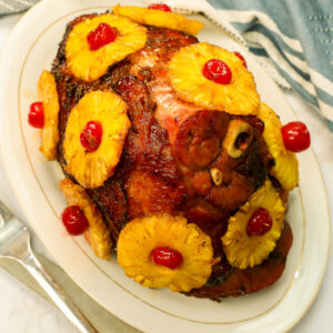 Succulent honey baked ham with caramelized pineapple slices and maraschino cherries