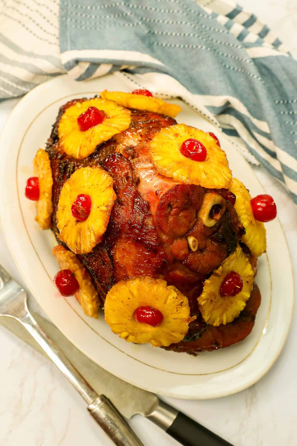 Succulent honey baked ham with caramelized pineapple slices and maraschino cherries