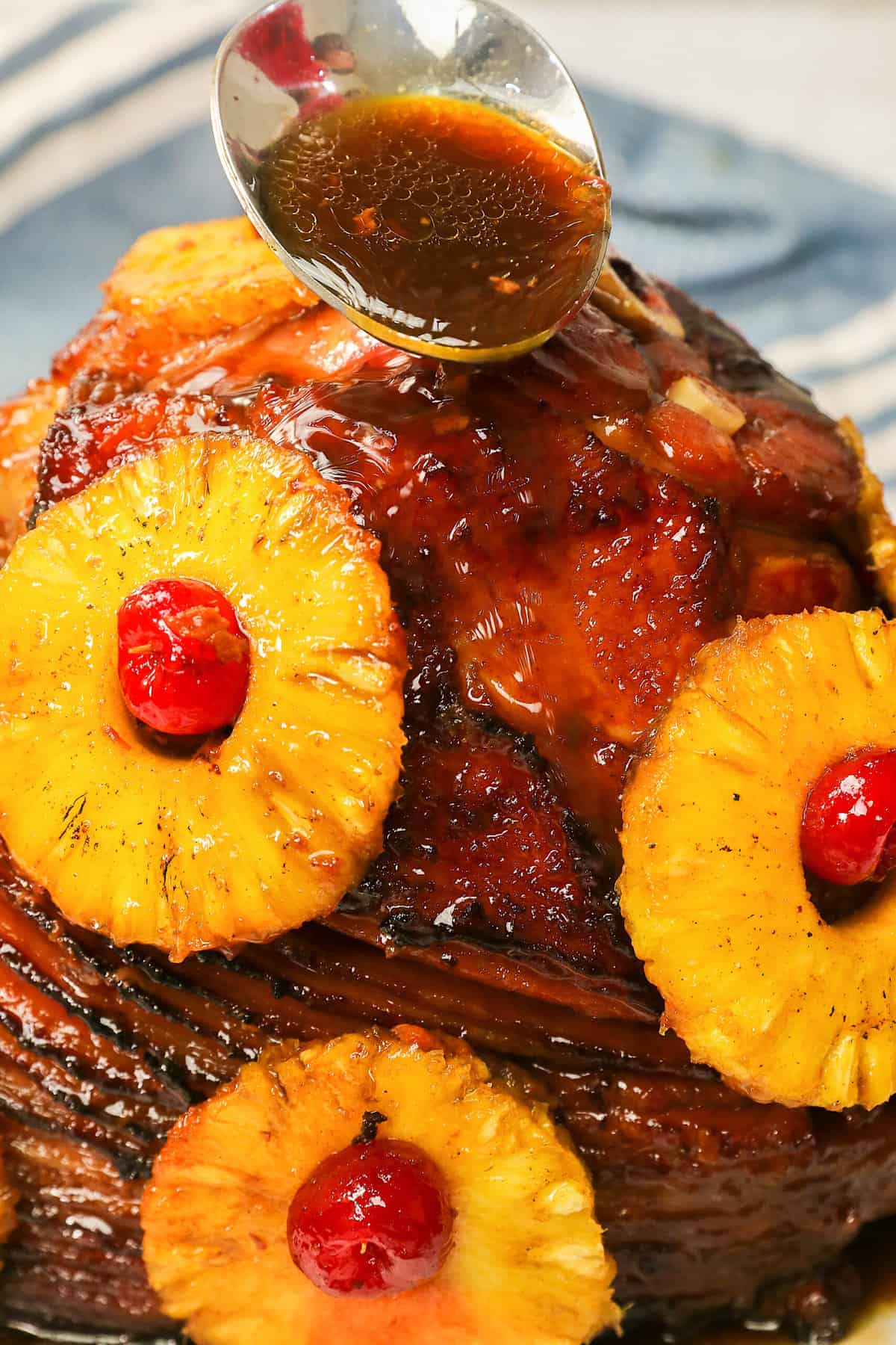 Drizzling more glaze over a delectable Pineapple Honey Baked Ham