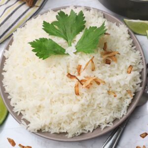 Tropically delicious Jasmine Coconut Rice garnished with cilantro and toasted coconut