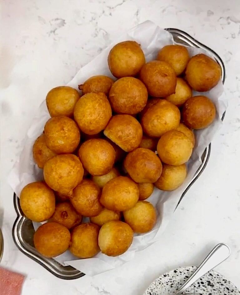 A platter loaded with freshly fried dough, puff puff.