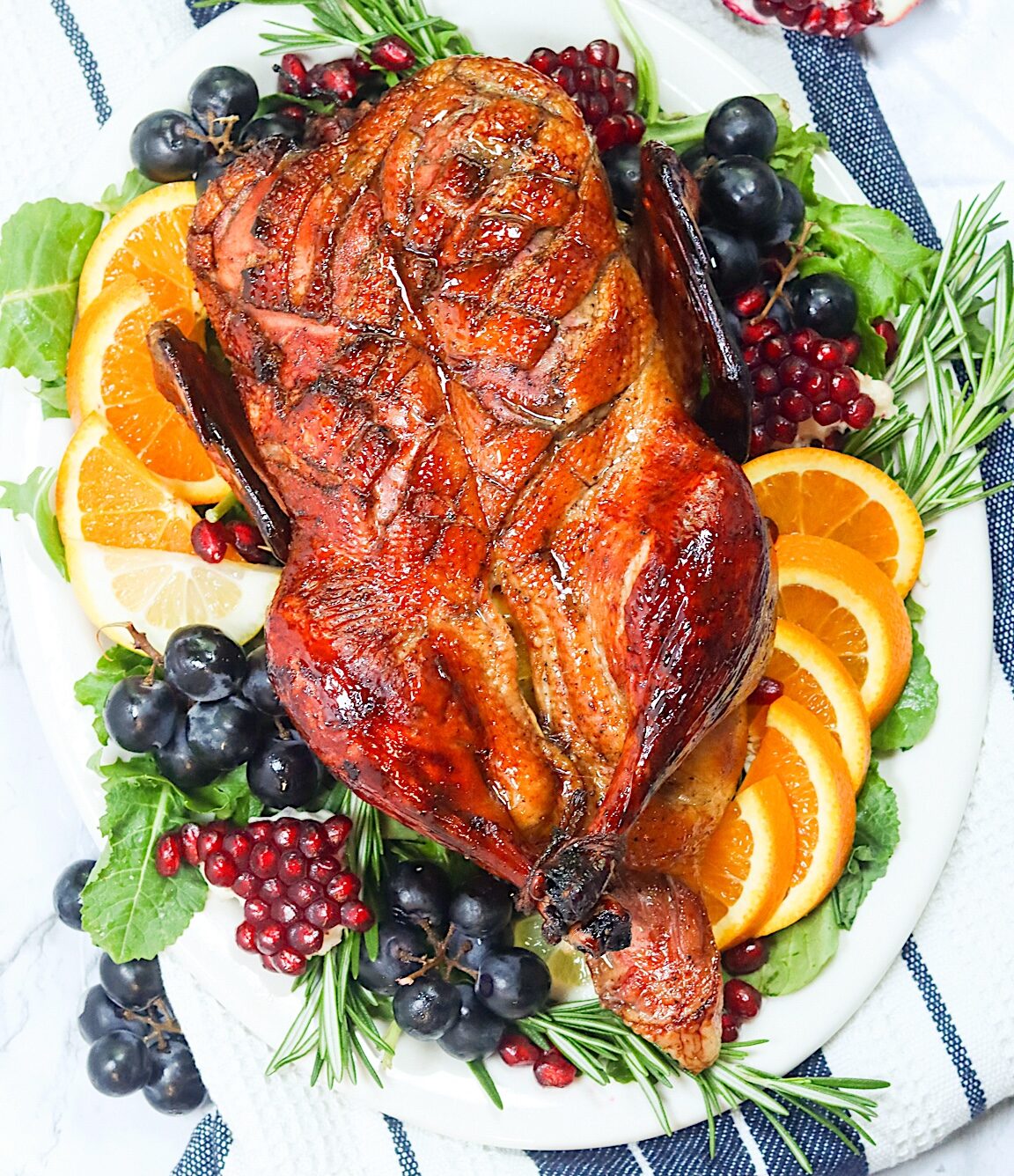 Whole Roast Duck on a gorgeous platter with grapes and orange slices