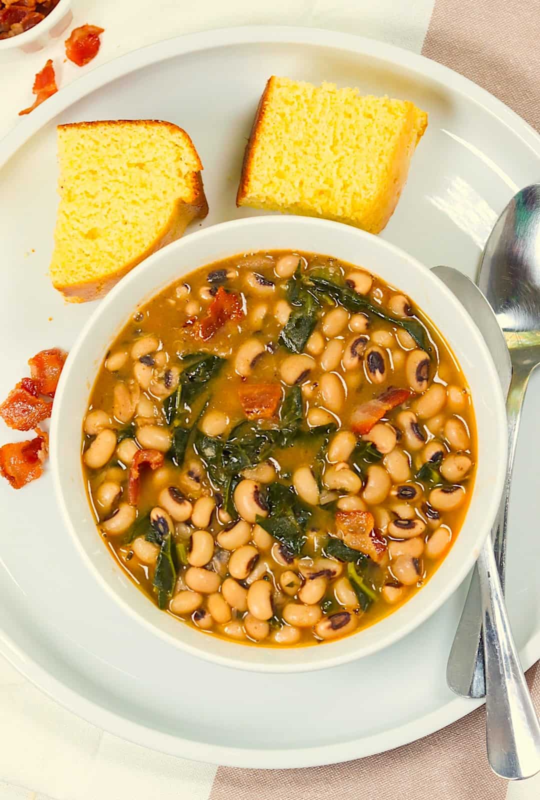 A steaming hot bowl of Black-Eyed Peas and Collard Greens and cornbread