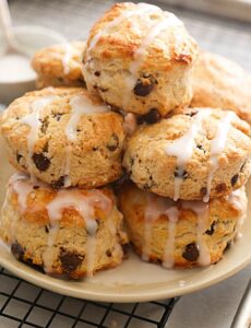 A decadent plateful of chocolate chip scones drizzled with glaze
