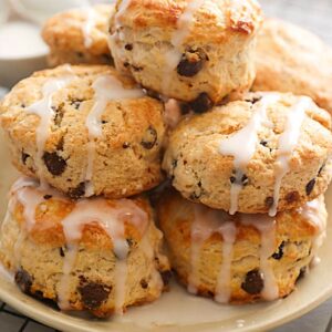 A decadent plateful of chocolate chip scones drizzled with glaze