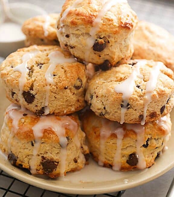 A decadent plateful of chocolate chip scones drizzled with glaze
