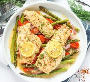 Delicious and healthy Baked Rockfish fresh from the oven with succulent vegetables on a white plate