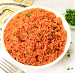 Steaming hot Charleston Red Rice served up in a white bowl and ready to enjoy