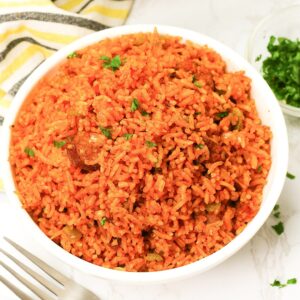 Steaming hot Charleston Red Rice served up in a white bowl and ready to enjoy
