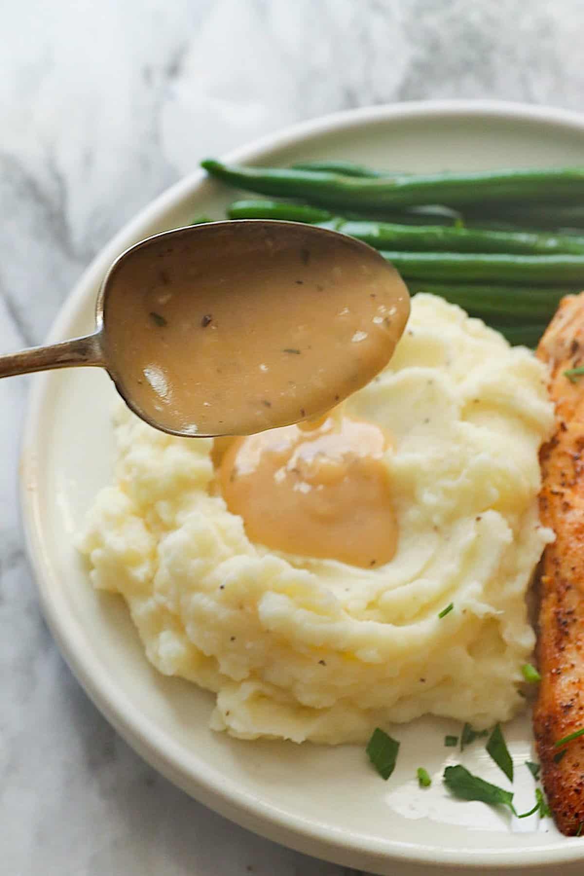 Drizzling comforting gravy over mashed potatoes