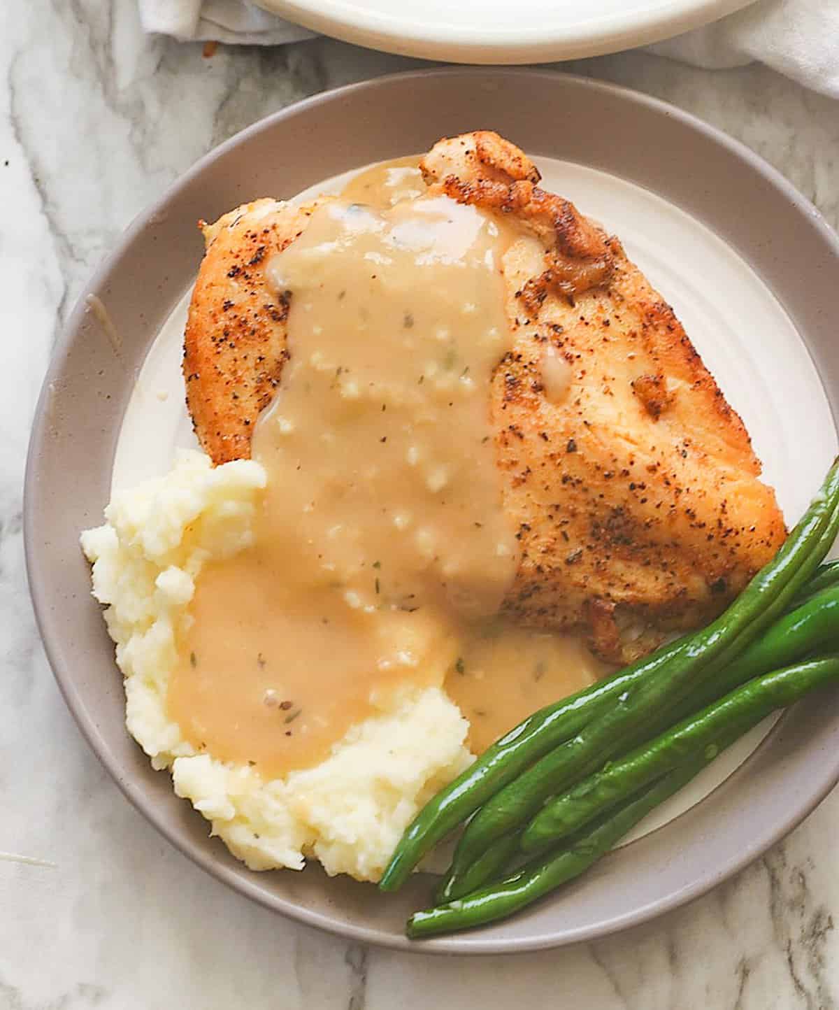 Enjoying a plateful of chicken and gravy with mashed potatoes and green beans