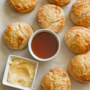 Insanely comforting Honey Butter Biscuits with honey butter and honey ready for drizzling