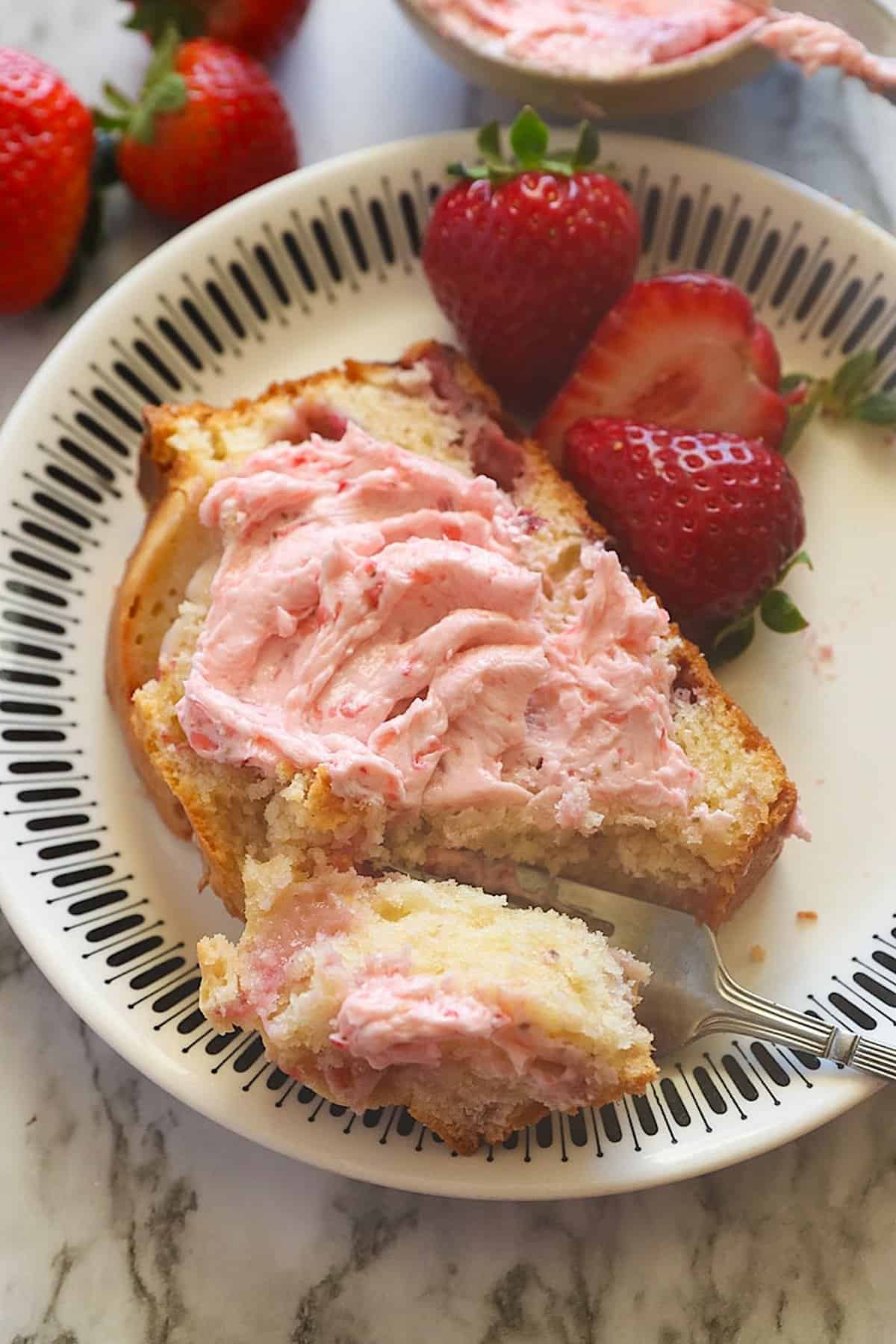 Slathering a freshly baked slice of strawberry bread with strawberry cream cheese