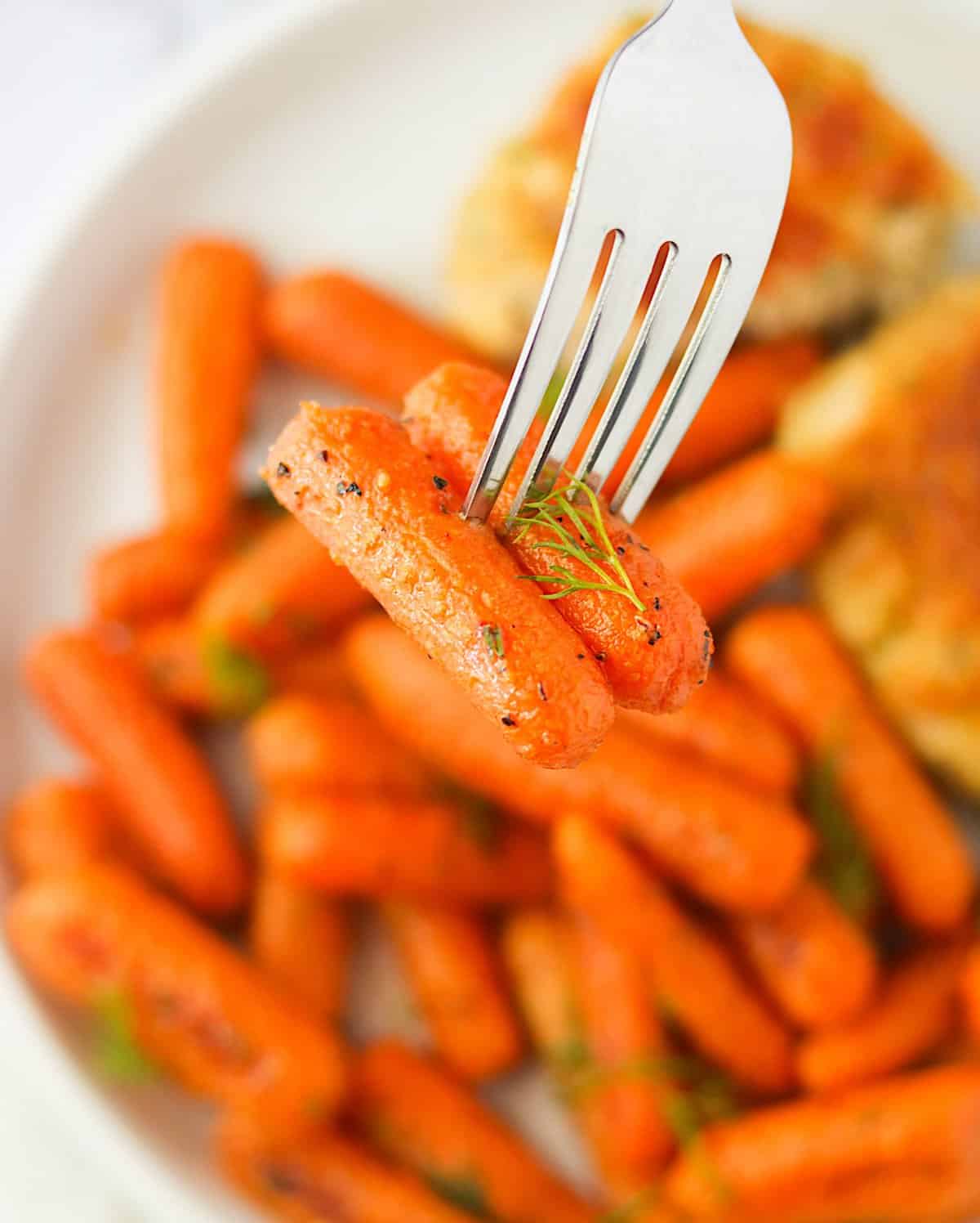 Taking a bite of Roasted Baby Carrots for a delectable side dish