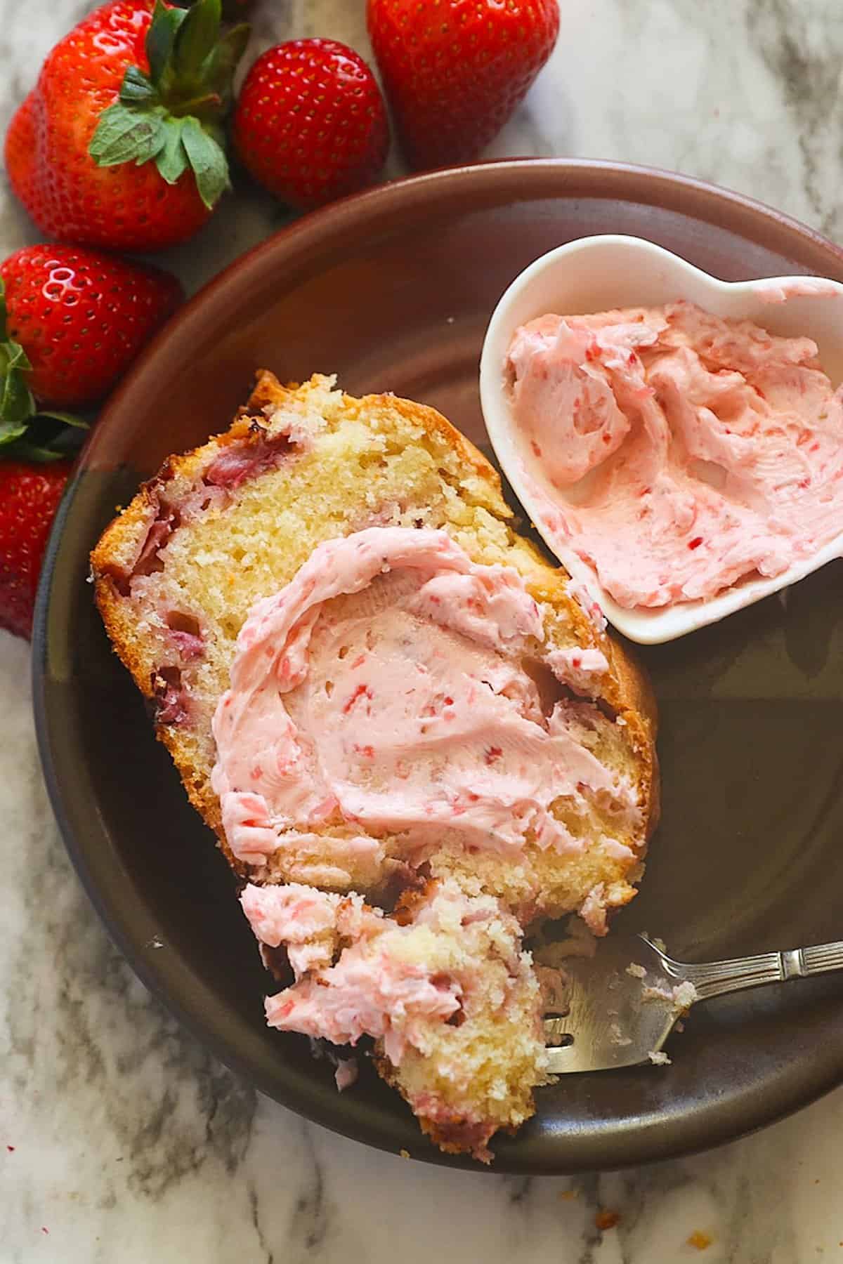 Spreading delectable strawberry butter on insanely delicious strawberry bread