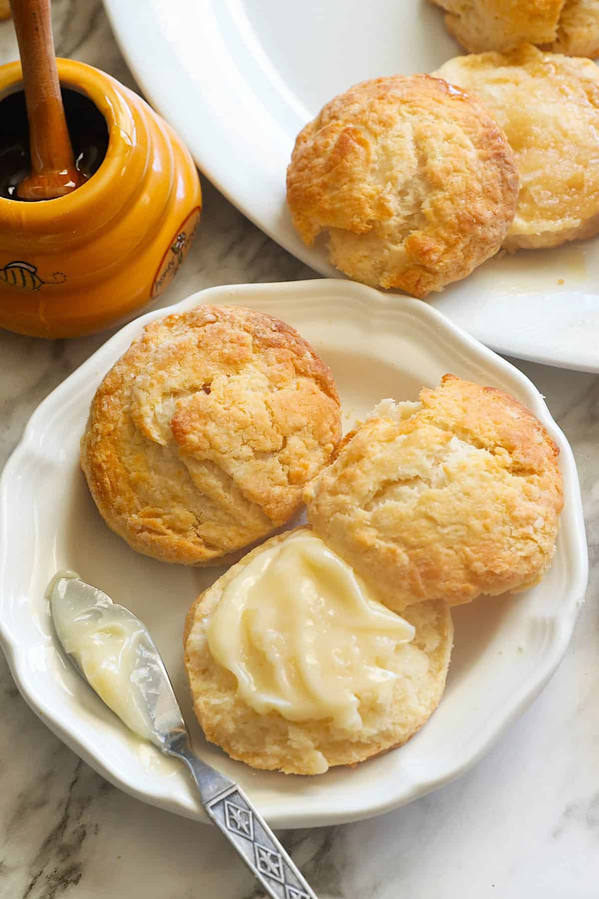 Slathering honey biscuits with honey butter for more decadence