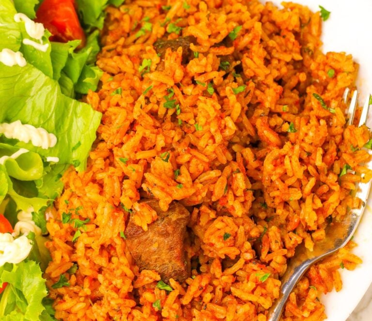 A delicious serving of Ghana jollof rice with a green salad for healthy soul food