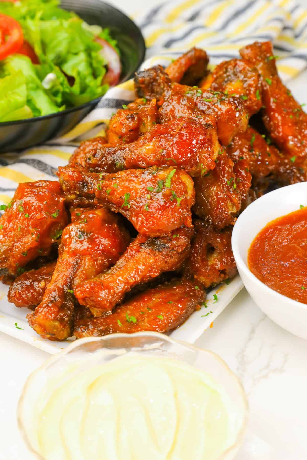 Mango Habanero Wings loaded up on a platter with more spicy dipping sauce and remoulade to cool it down if needed