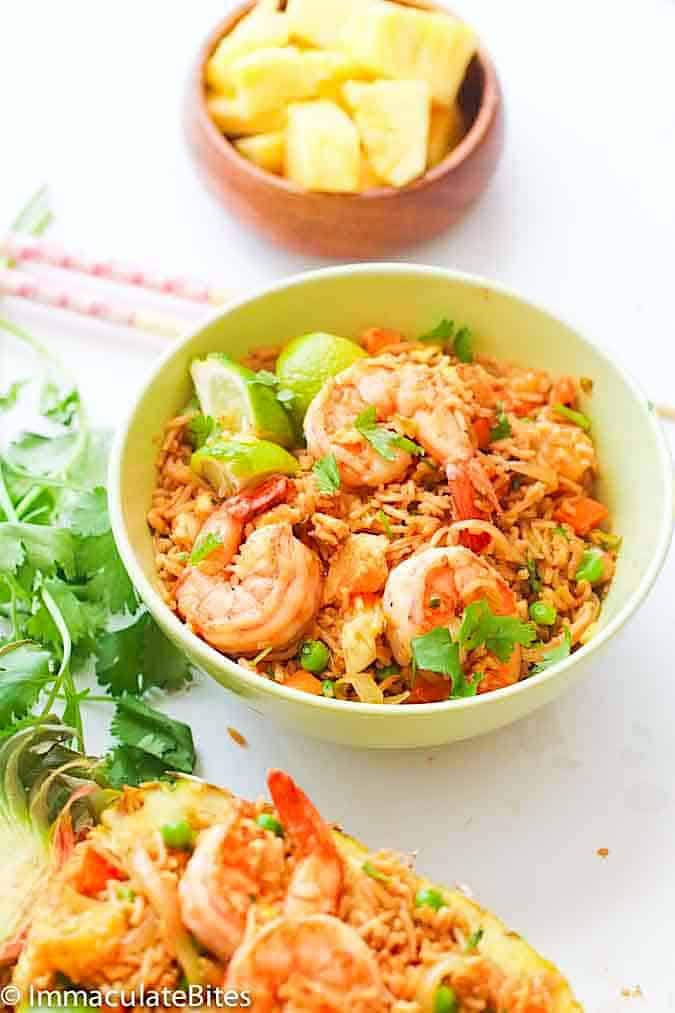 Serving up a delectable bowl of pineapple fried rice with extra pineapple in the background