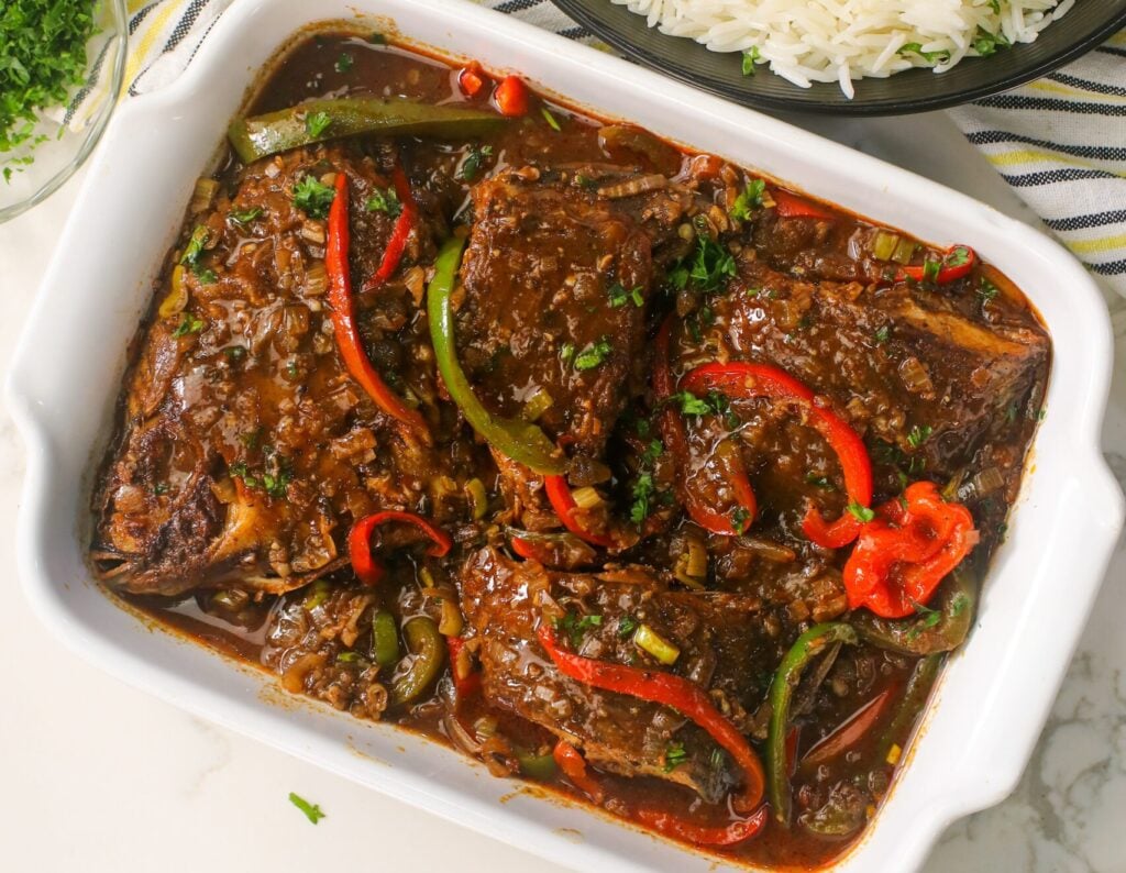 Serving up a platter of Jamaican brown stewed fish with steaming rice