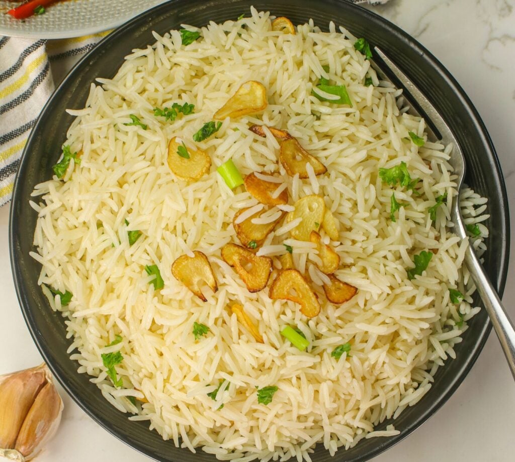 Serving up a savory bowl of garlic rice with a spicy main dish