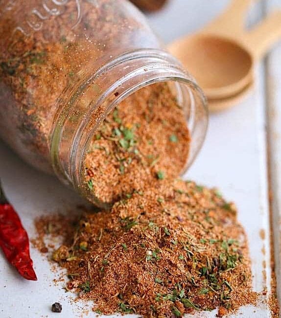 Spicy and flavorful Jamaican jerk seasoning spilling out of a glass jar