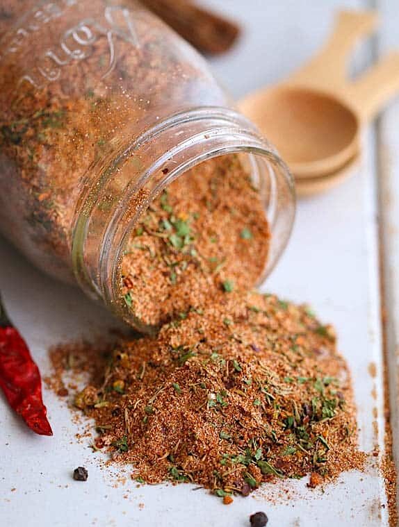 Spicy and flavorful Jamaican jerk seasoning spilling out of a glass jar