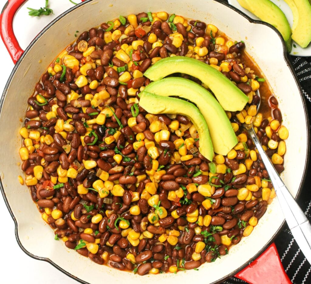 Getting ready to serve freshly made githeri with avocado slices