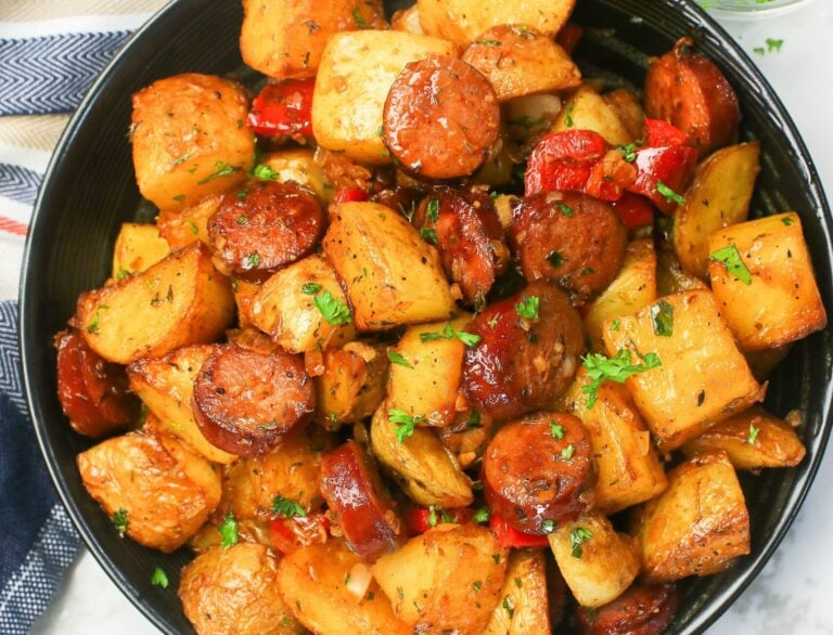 Serving up a black plate loaded with sausage and potatoes for comfort food deliciousness