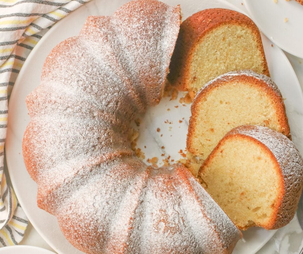 Fresh pound cake dusted with powdered sugar, sliced, and ready to enjoy