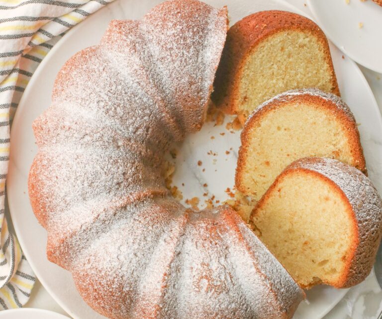 Fresh pound cake dusted with powdered sugar, sliced, and ready to enjoy