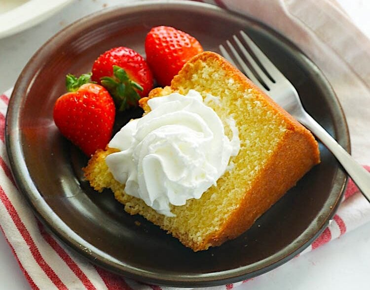 Enjoying a slice of Southern pound cake with fresh strawberries and a dollop of homemade whipped cream