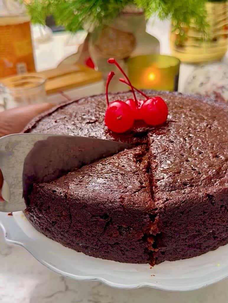 Slicing into a Caribbean black cake for a traditional Christmas fruitcake.