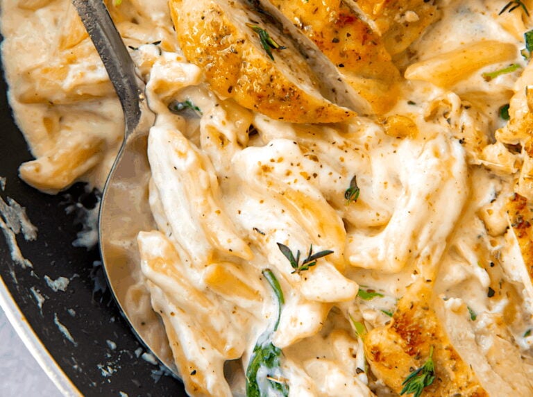 Serving up creamy Alfredo sauce smothering penne pasta and topped with pan-fried chicken breast