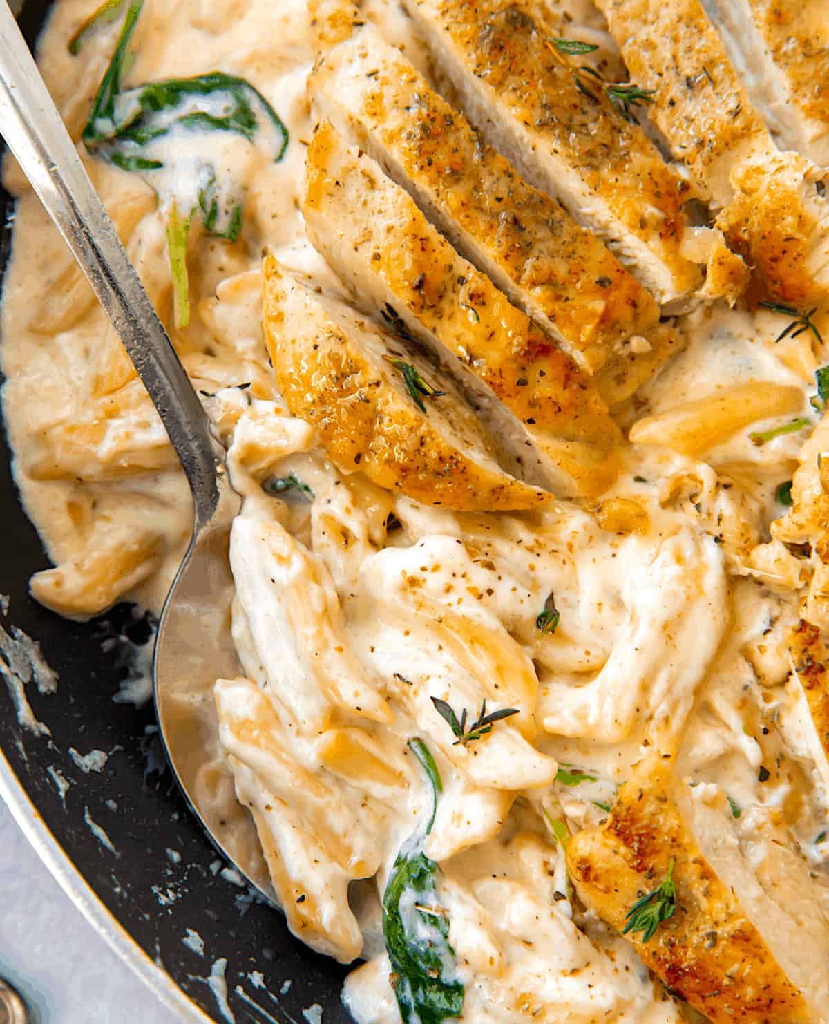 Serving up creamy Alfredo sauce smothering penne pasta and topped with pan-fried chicken breast